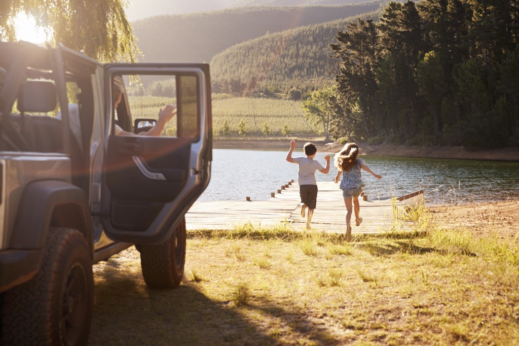 family reaching destination by lake after road trip