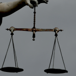 Scales of justice being held by a statue