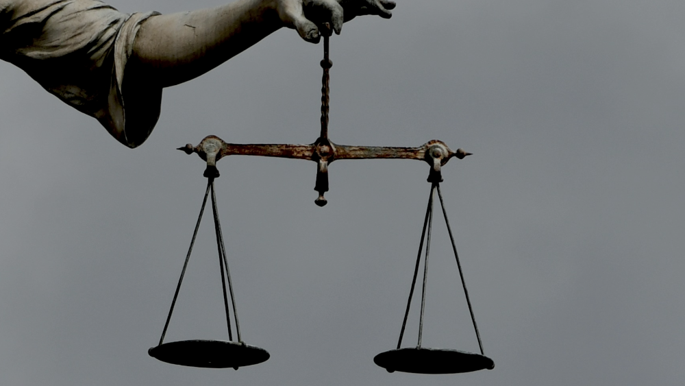 Scales of justice being held by a statue