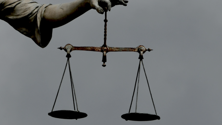 Scales of justice being held by a statue
